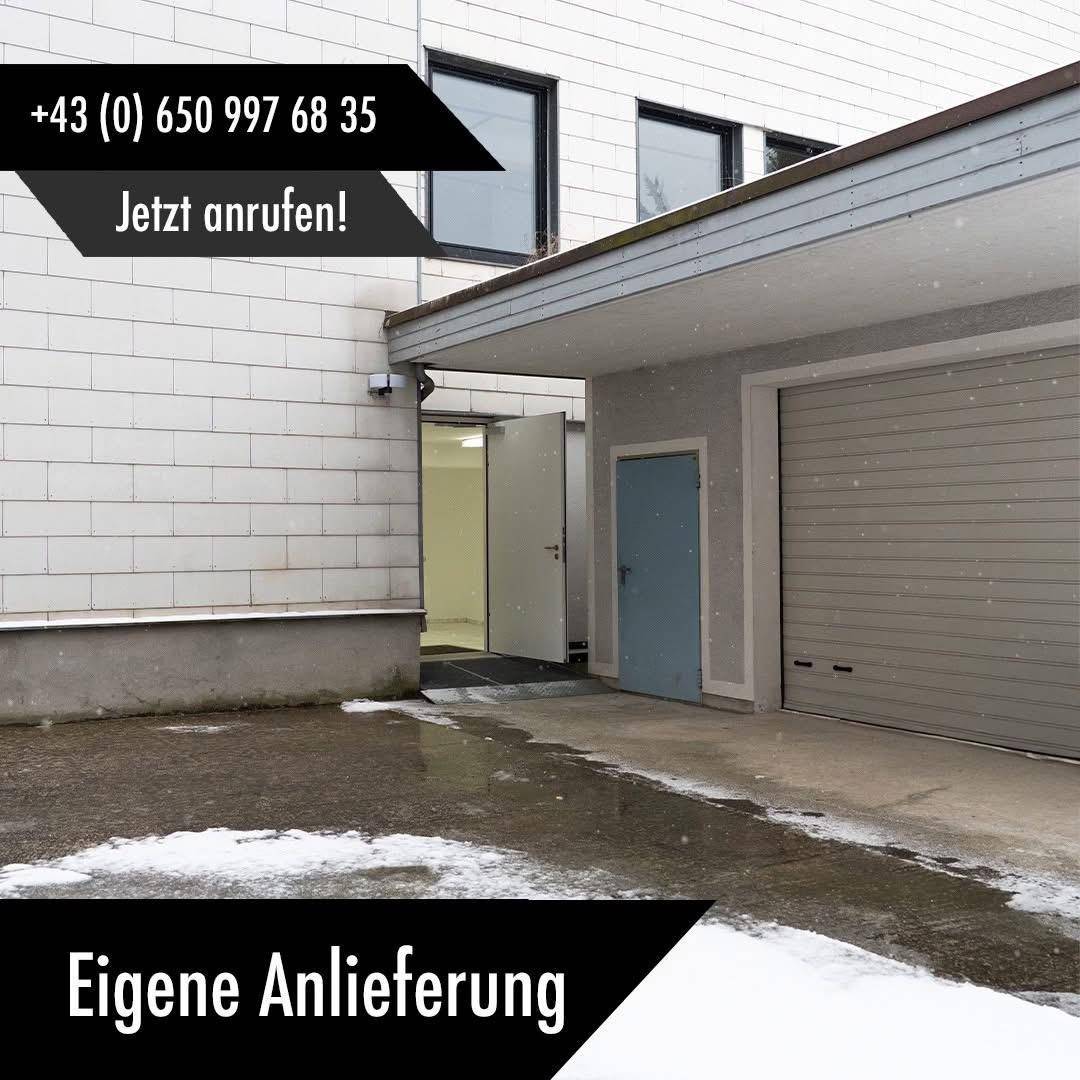 Außenansicht eines Gebäudes mit Garagentoren und einem Eingangsbereich, teilweise schneebedeckt.