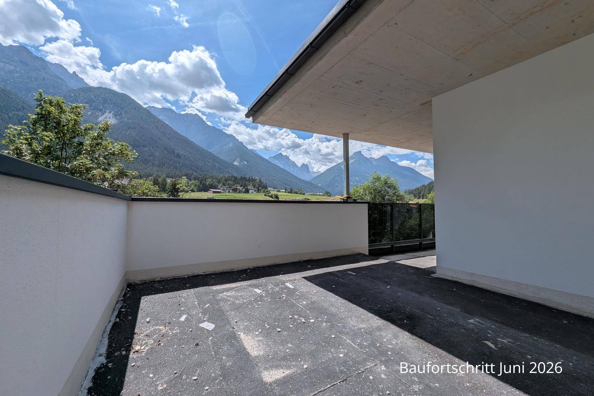 Große, noch unfertige Terrasse mit schützender Brüstung und beeindruckendem Bergblick.