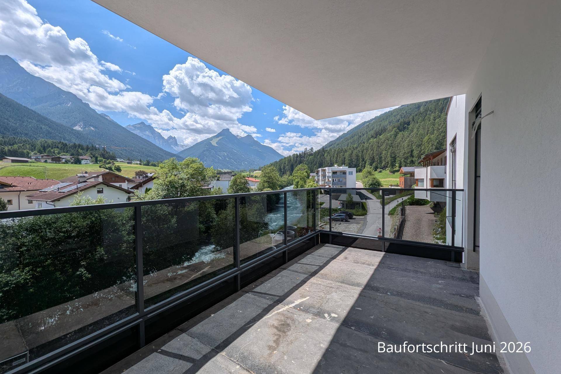 Langer Balkon mit Glasgeländer und beeindruckendem Panoramablick auf die Alpen und das Flusstal.