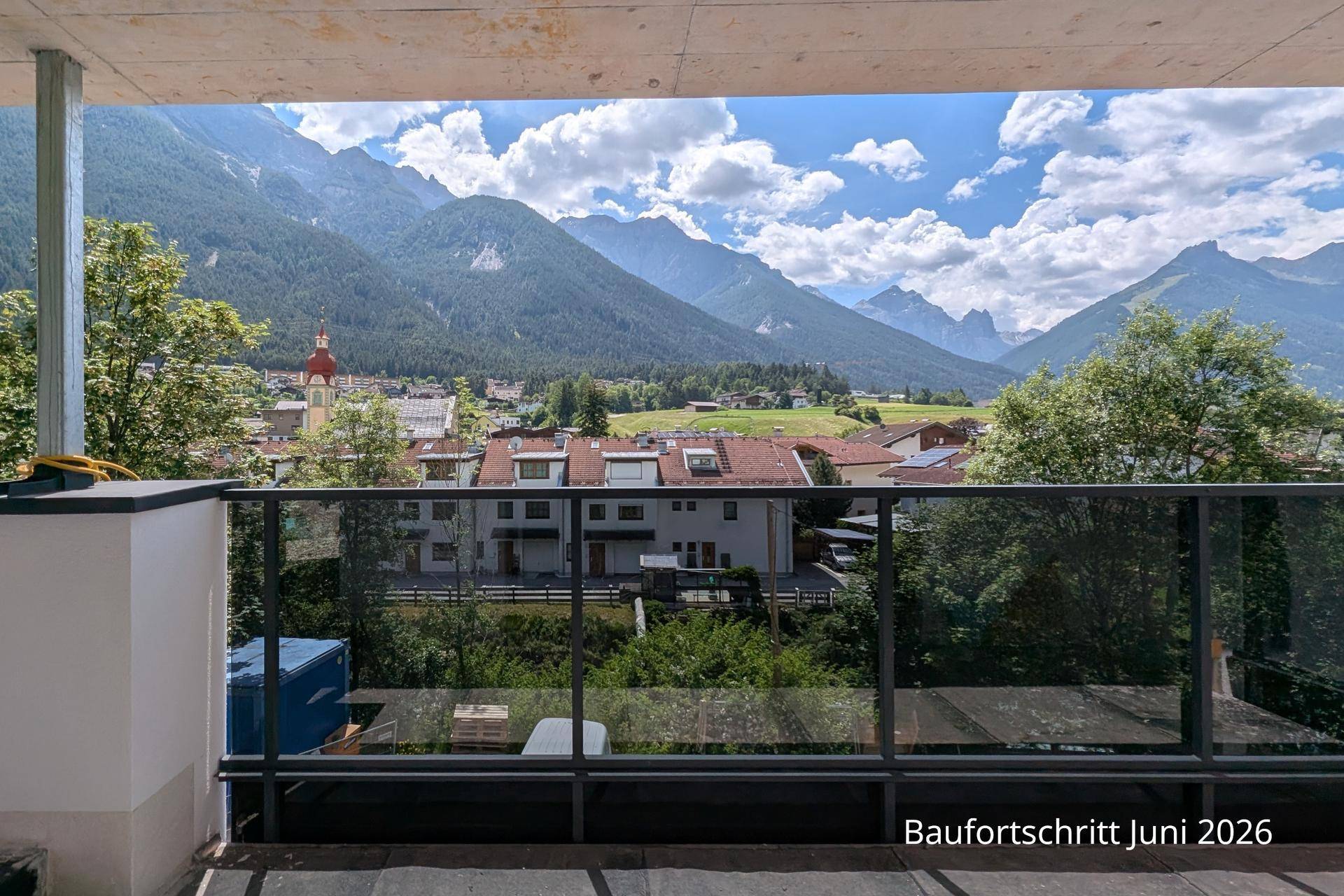 Geräumiger Balkon mit Panoramablick auf die Alpen und das charmante Dorf im Tal.