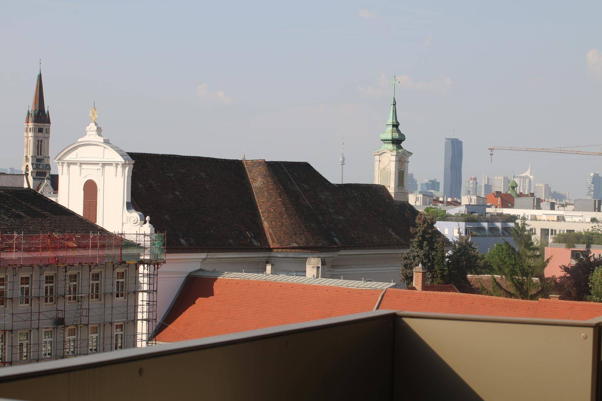 Panoramablick über die Stadt mit historischen Gebäuden und moderner Skyline im Hintergrund.
