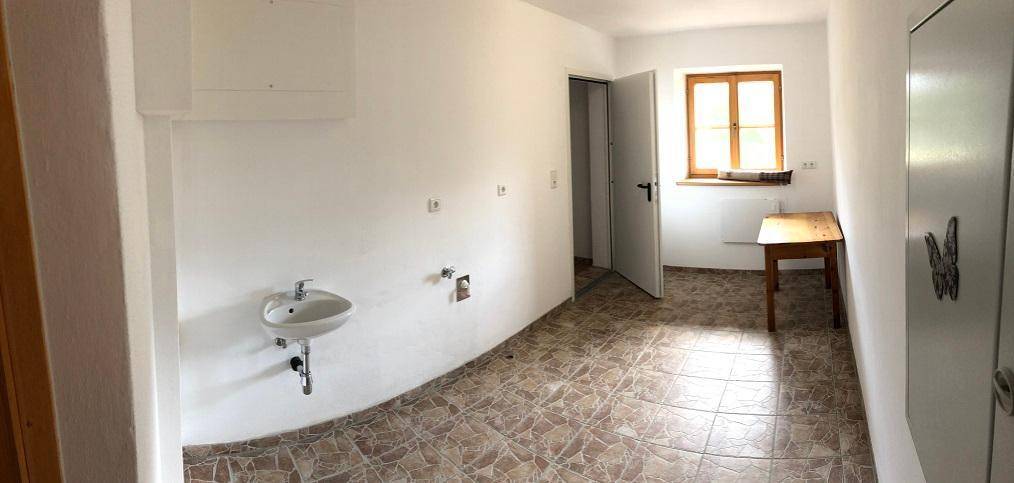 Geräumiger Hauswirtschaftsraum mit Waschbecken, Fliesenboden und einem Fenster.