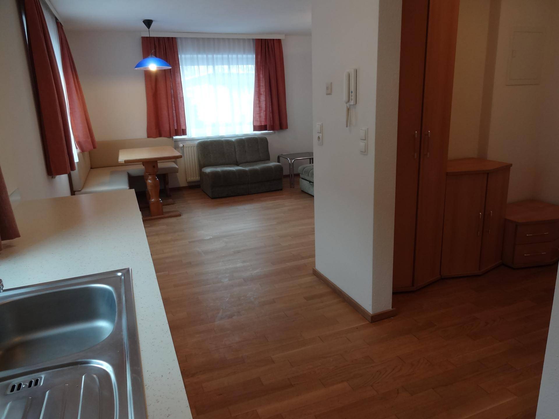 Blick von der Küchenzeile in den offenen Wohn- und Essbereich mit Holzboden.