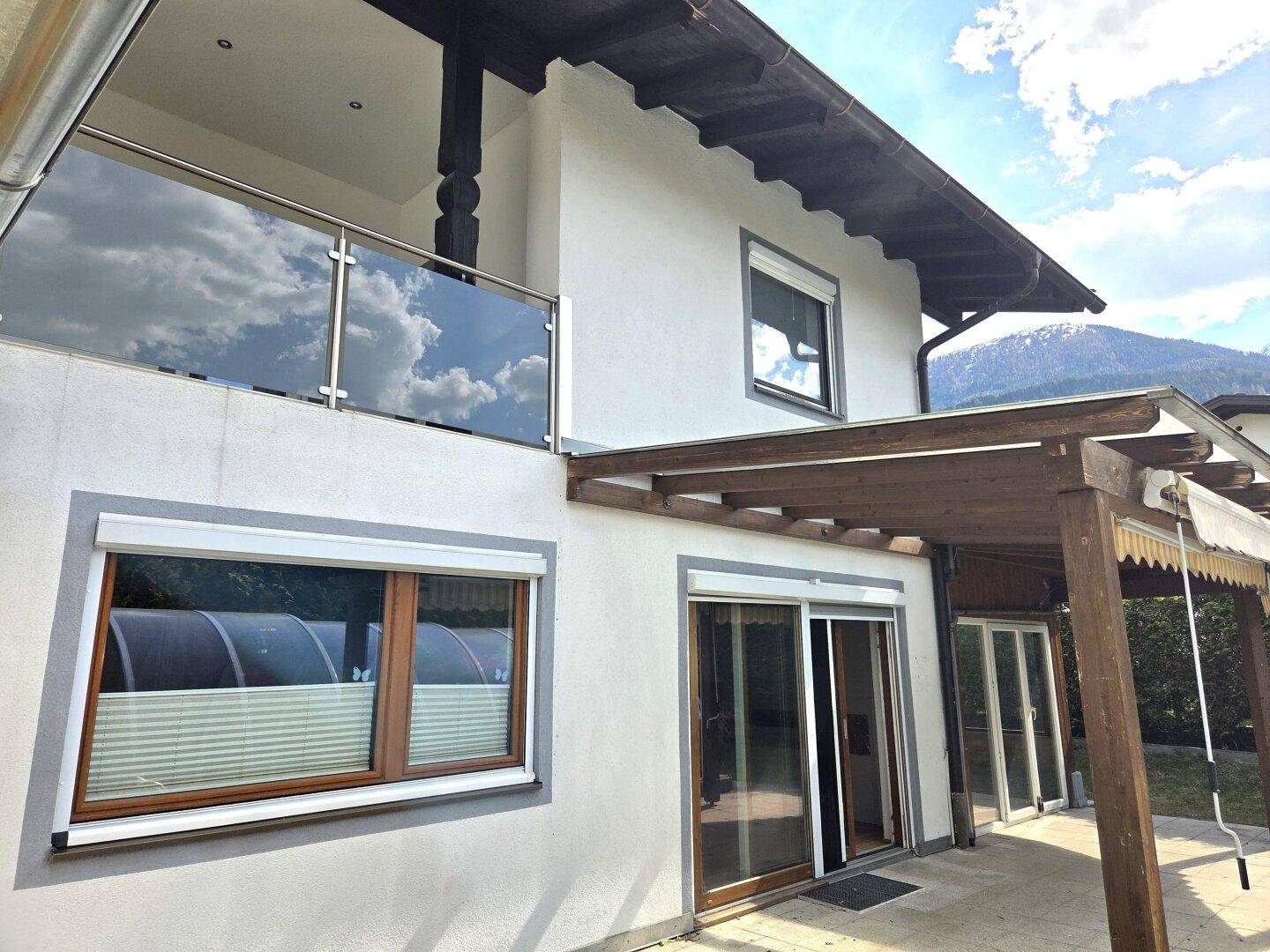 Außenansicht des Hauses mit Balkon, Terrasse und moderner Architektur.