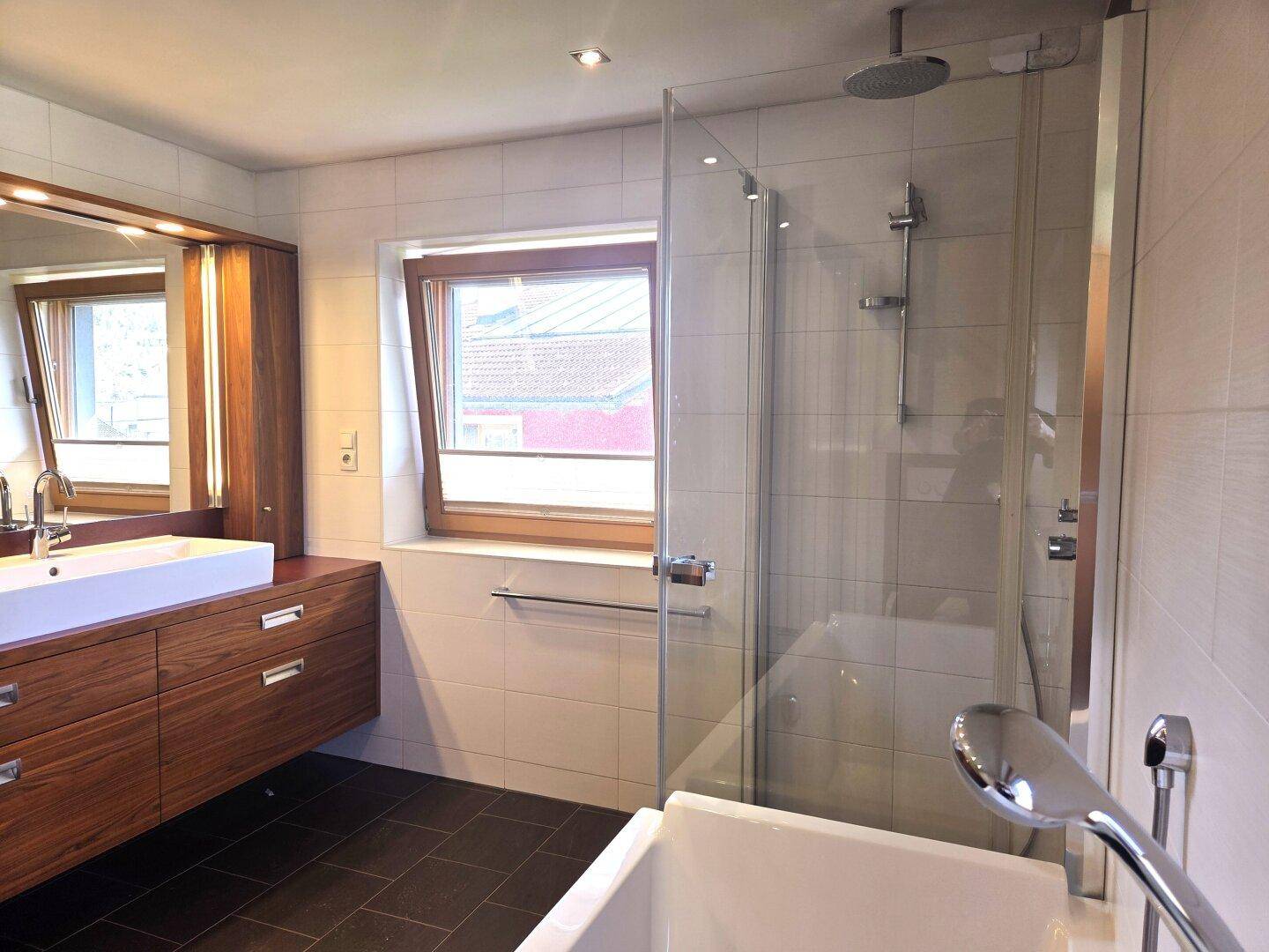 Modernes Badezimmer mit Holzelementen, großem Waschbecken und begehbarer Dusche.