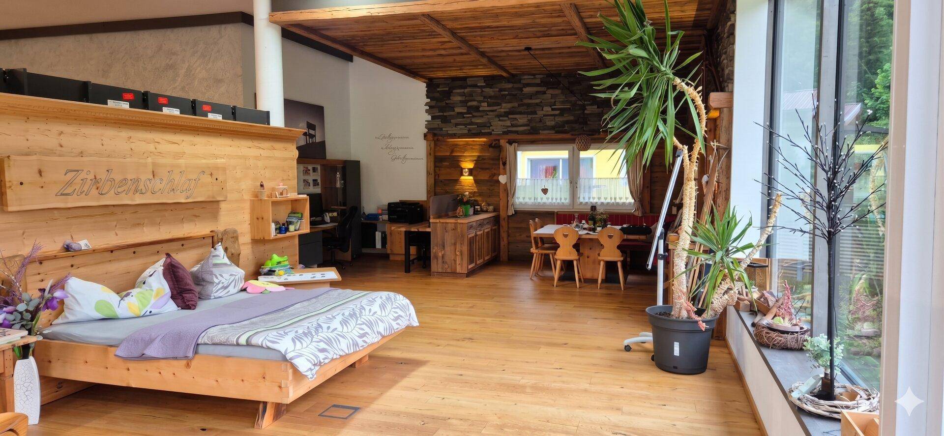 Gemütliches Schlafzimmer mit viel Holz, Zirbenholz-Elementen und großen Fenstern.