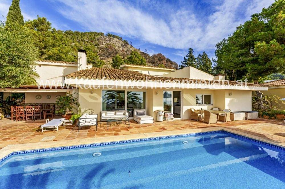 Außenansicht der Villa mit großem Pool, Sonnenterrasse und Bergblick.