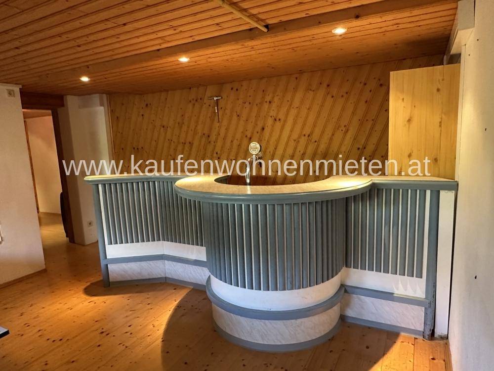 Rustikaler Barbereich mit Holzwänden und -decke, ideal für gesellige Abende.