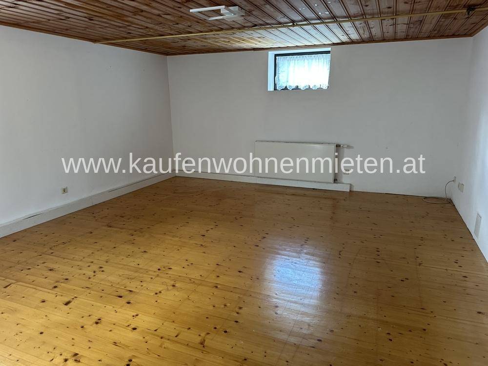 Heller Raum mit Holzdielenboden und Holzdecke, vielseitig nutzbar als Kellerraum.
