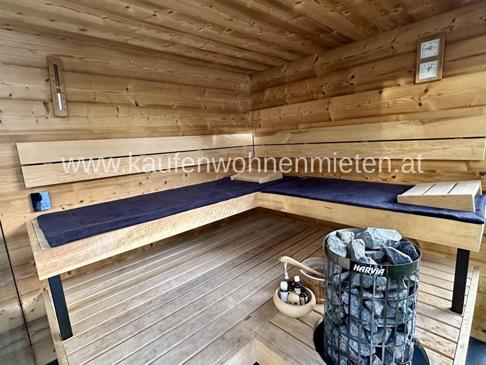 Gemütliche Holzsauna mit Bänken und einem modernen Saunaofen für entspannende Momente.