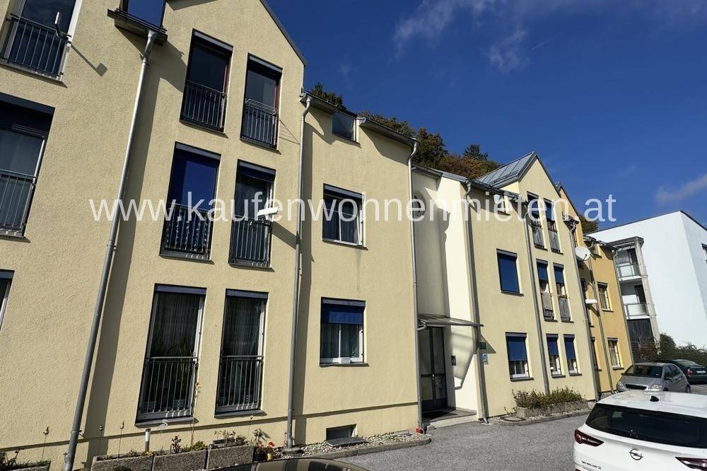 Reihe von modernen Wohngebäuden mit gelber Fassade und französischen Balkonen an einem sonnigen Tag.