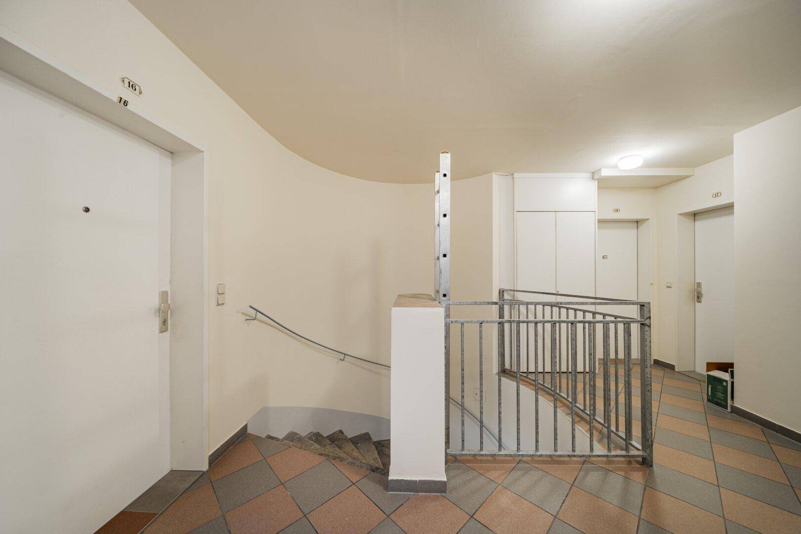 Gemeinschaftlicher Flur mit Treppenhaus und Zugang zu den Wohnungen, gefliestem Boden.