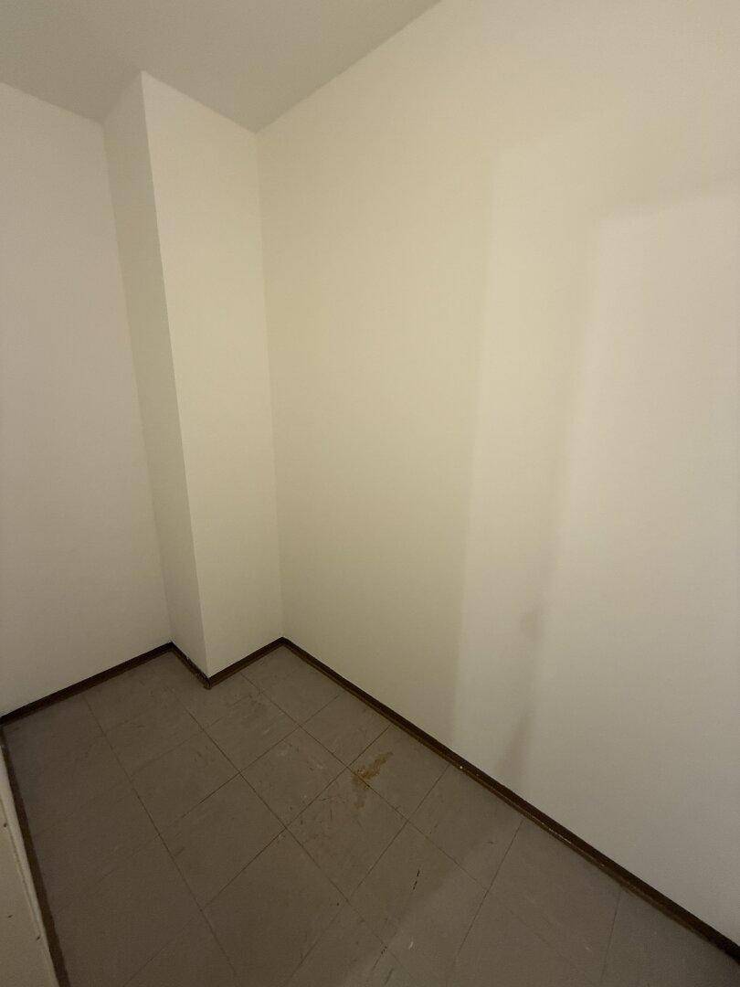 Kleiner, leerer Raum mit Fliesenboden und weißen Wänden, ideal als Abstellkammer.