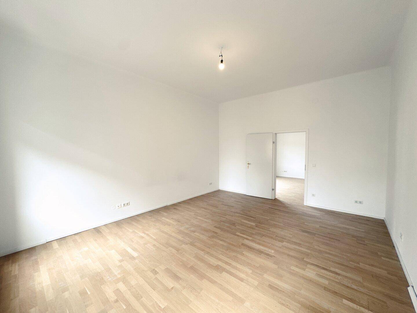 Geräumiges Zimmer mit Parkettboden und Doppeltüren, bietet vielseitige Einrichtungsmöglichkeiten.