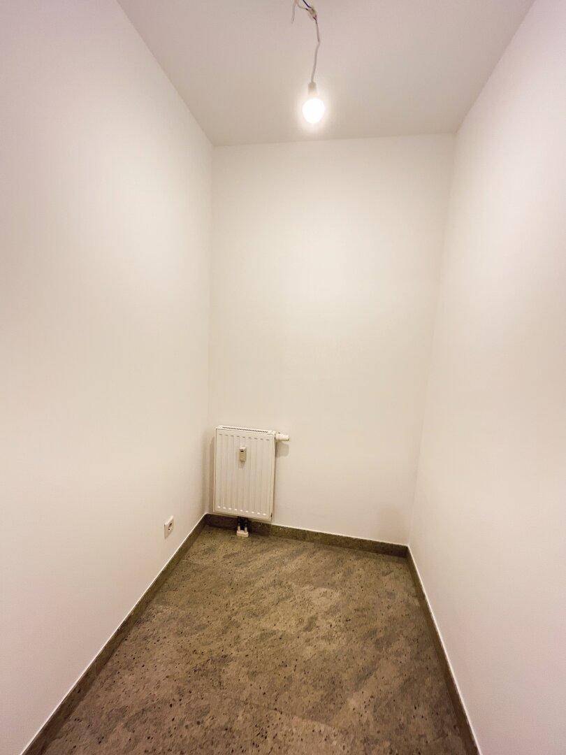 Kleiner Abstellraum mit Fliesenboden und Heizkörper, ideal für zusätzlichen Stauraum.