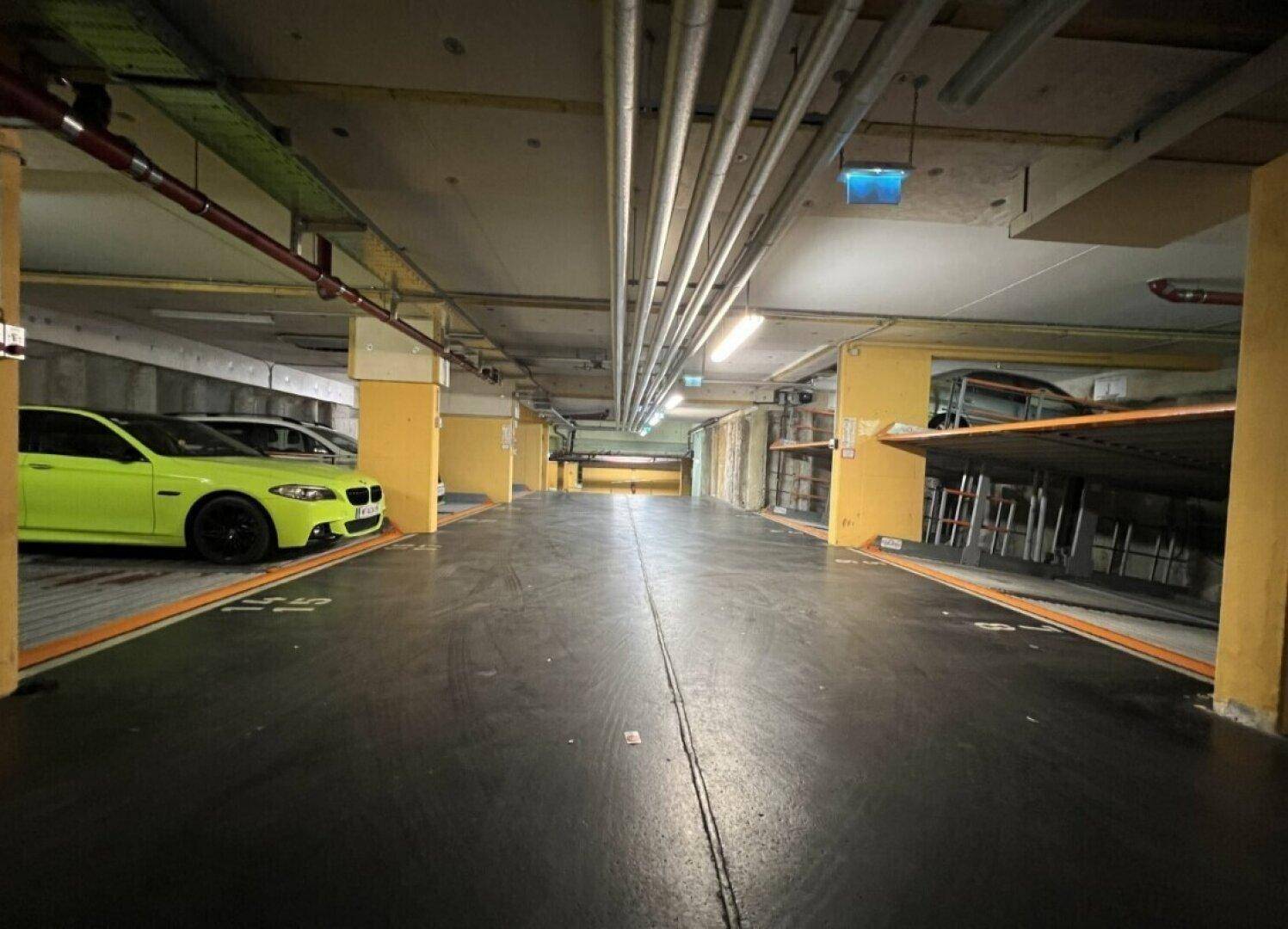 Tiefgarage mit mehreren Stellplätzen und Beleuchtung, bietet sichere Parkmöglichkeiten.