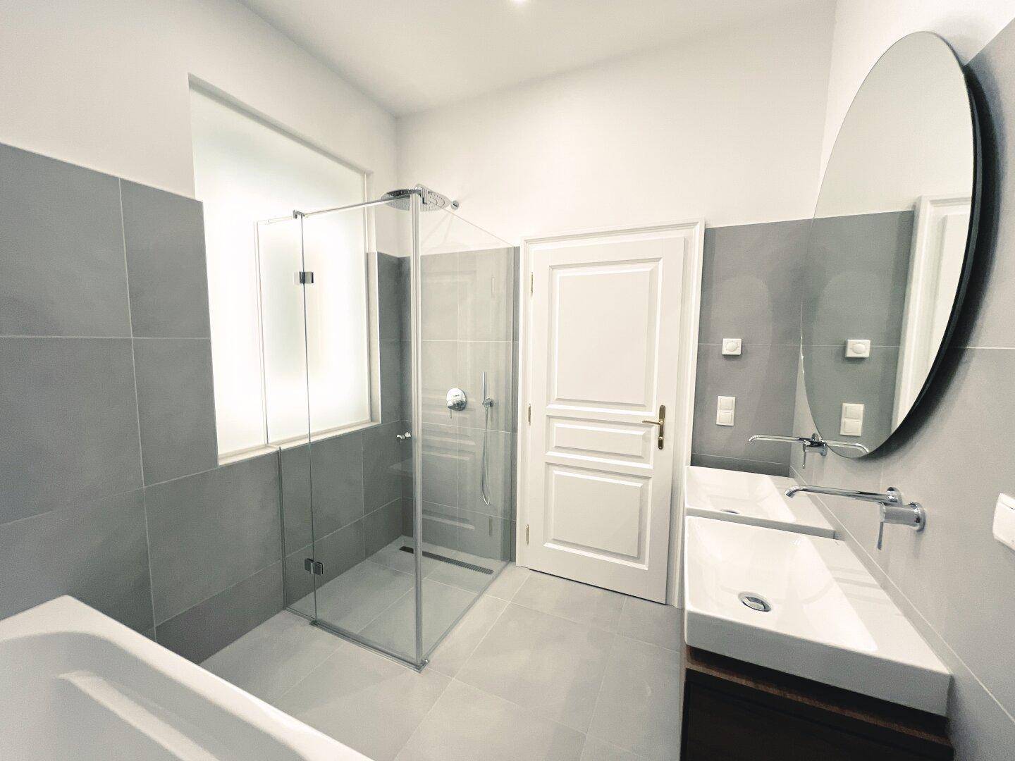 Modernes Badezimmer mit großer Dusche, Doppelwaschbecken und Badewanne, sehr geräumig.
