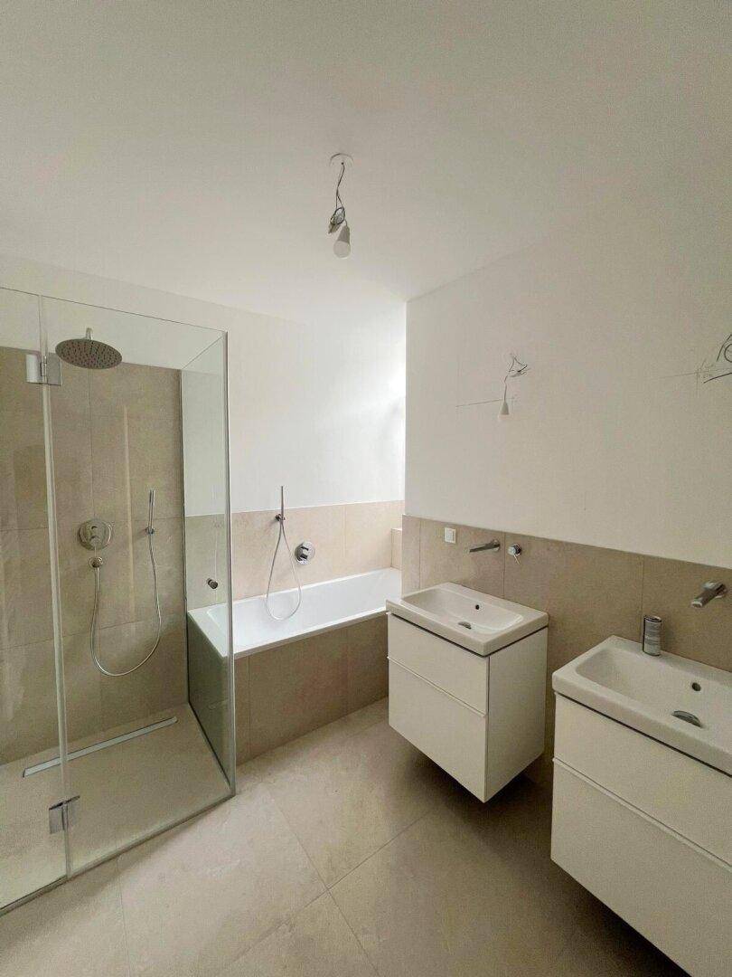 Modernes Badezimmer mit doppelten Waschbecken, Badewanne und begehbarer Dusche.
