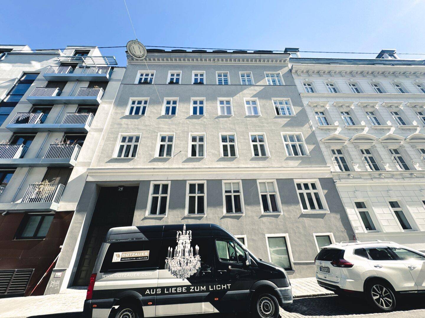 Historisches Gebäude mit klassischer Fassade und vielen Fenstern an einer städtischen Straße.