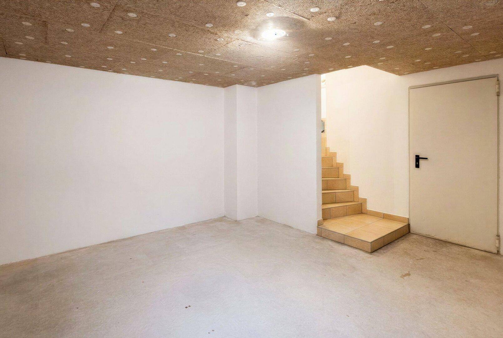Unfertiger Kellerraum mit Betonboden und Treppenzugang, bereit für den Ausbau.