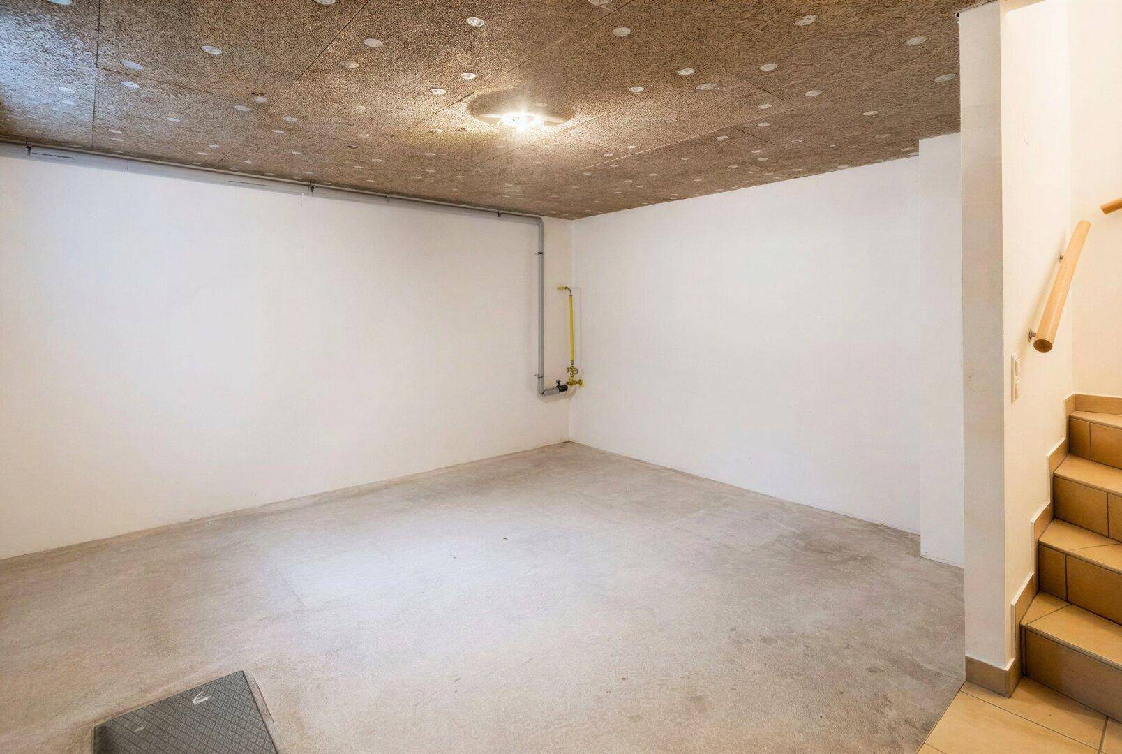 Geräumiger Kellerraum mit Betonboden und sichtbaren Installationen, ideal als Lagerfläche.