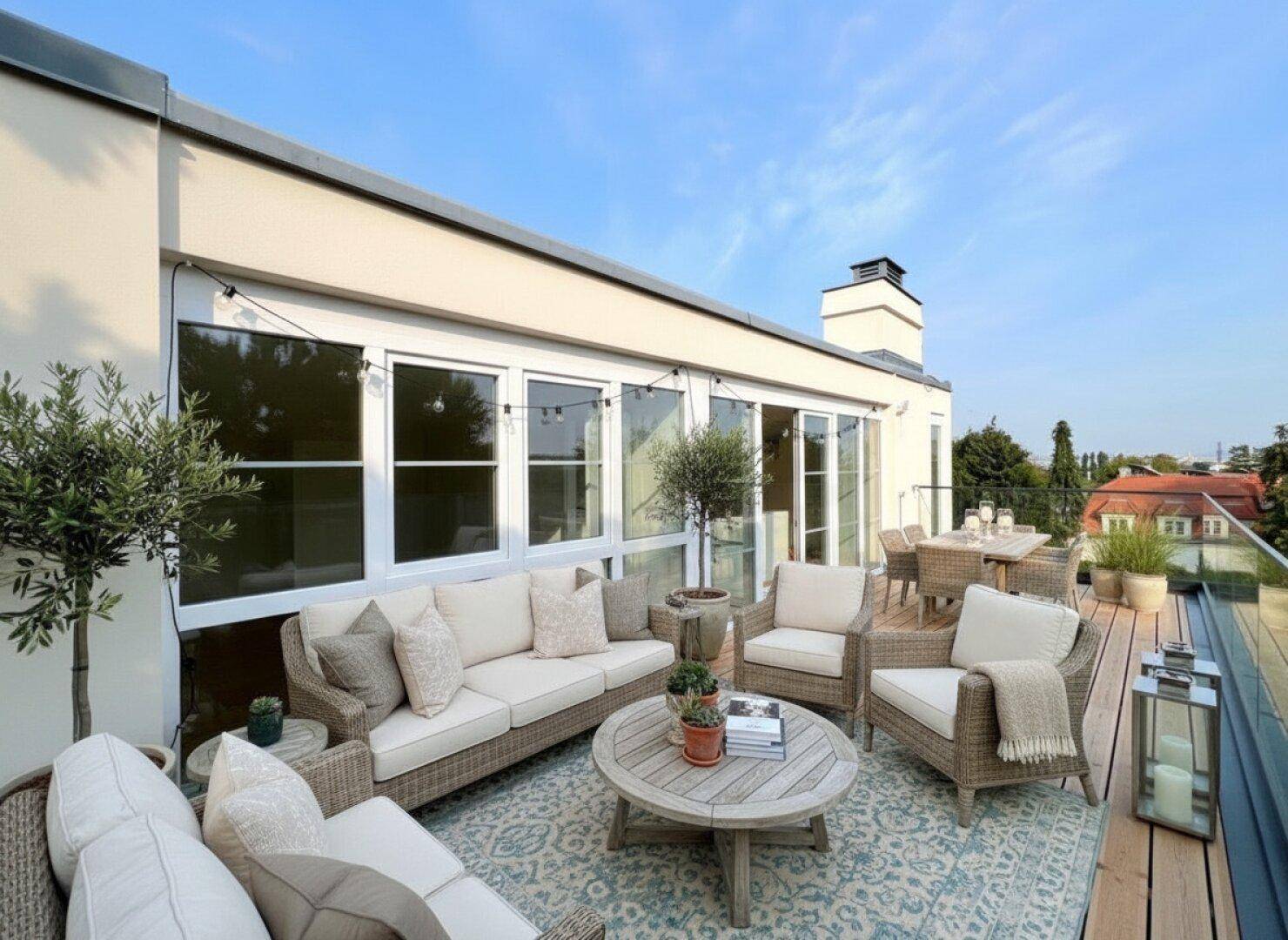 Geräumige Dachterrasse mit bequemen Loungemöbeln, Esstisch und weitem Blick über die Umgebung.