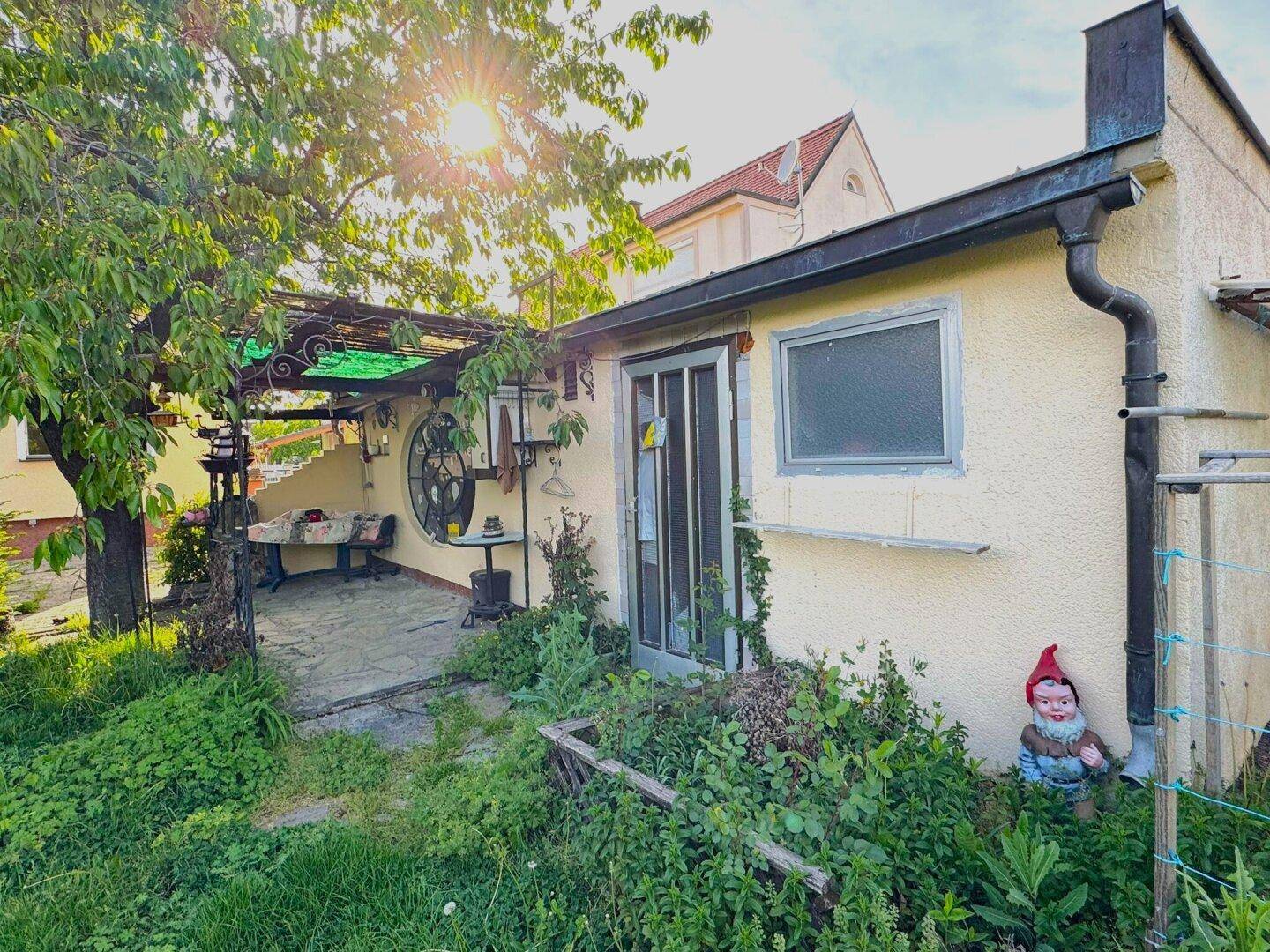 Kleiner Gartenbereich mit Terrasse, Pflanzen und einem Gartenzwerg.