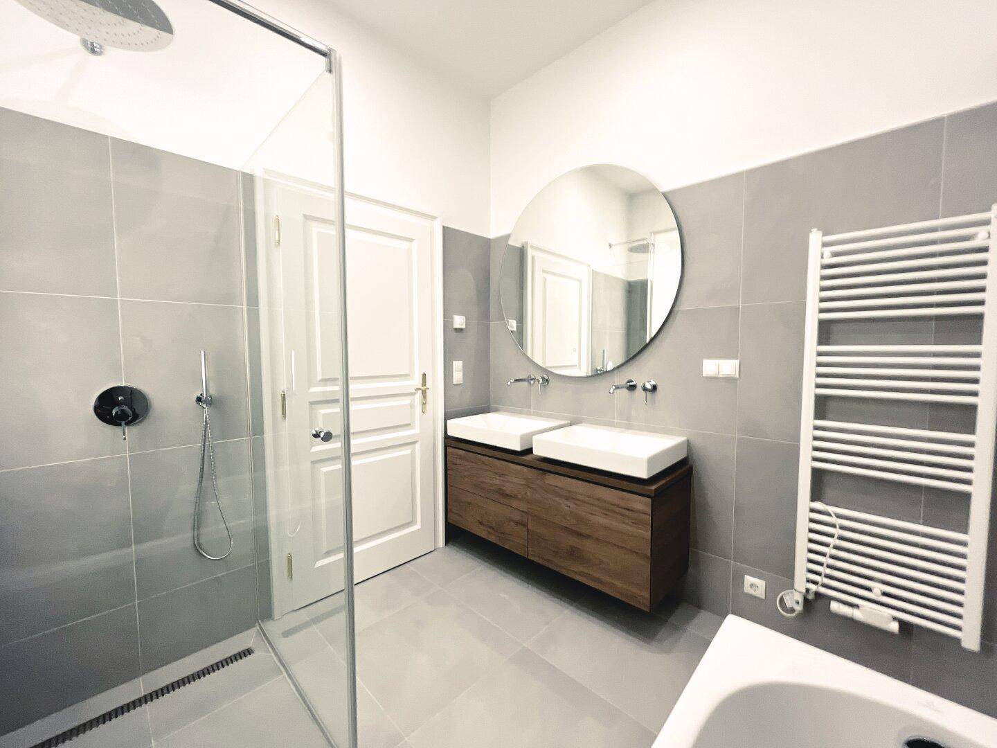 Modernes Badezimmer mit Doppelwaschbecken, begehbarer Dusche und Badewanne, sehr stilvoll gestaltet.