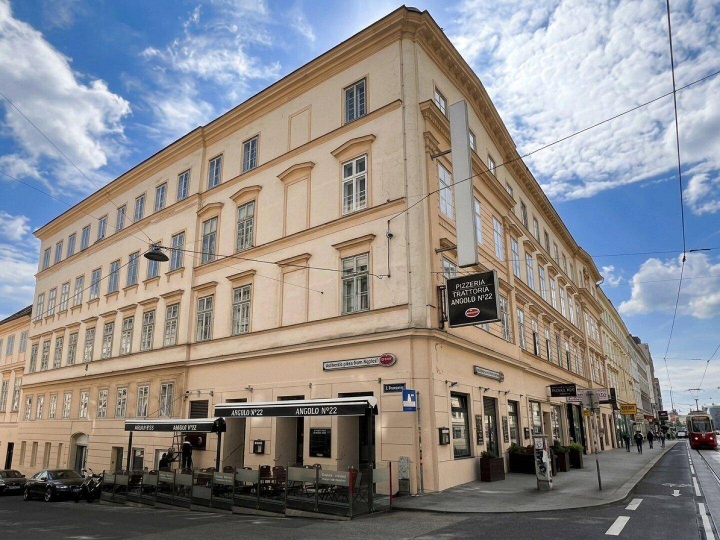 Detailansicht des historischen Eckgebäudes mit Restaurant im Erdgeschoss und traditioneller Fassadengestaltung.