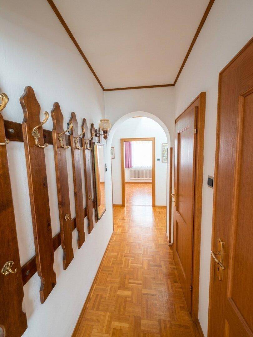 Flur mit Parkettboden, Garderobe und Blick in den hinteren Bereich.