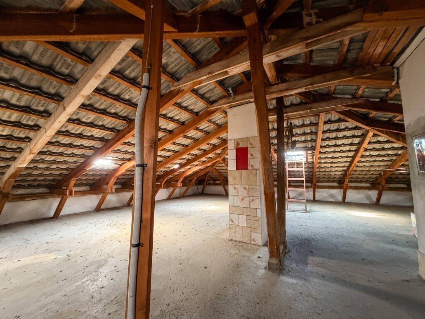 Heller Dachboden mit offener Holzkonstruktion und viel ungenutztem Raum für zukünftige Projekte.