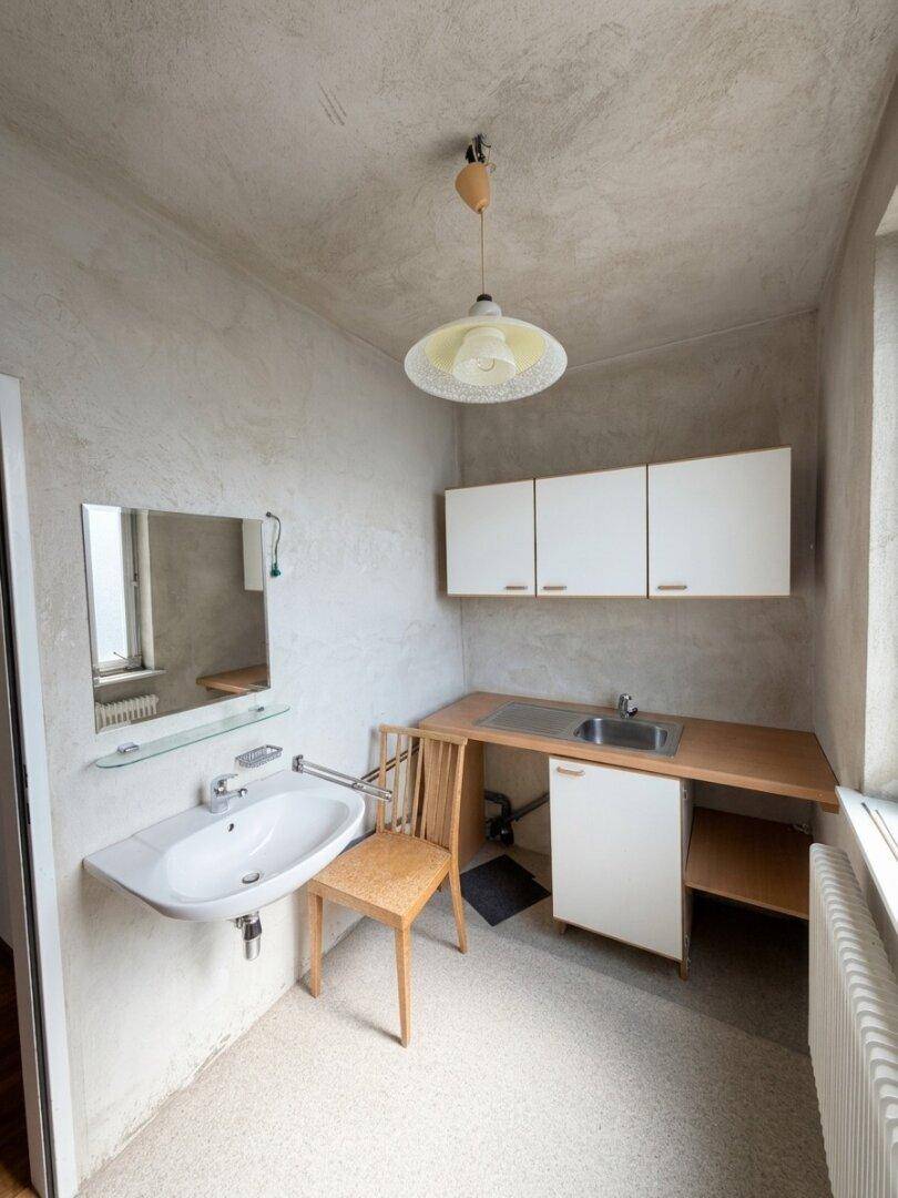 Kleiner Hauswirtschaftsraum mit Waschbecken, Arbeitsplatte und Hängeschränken.