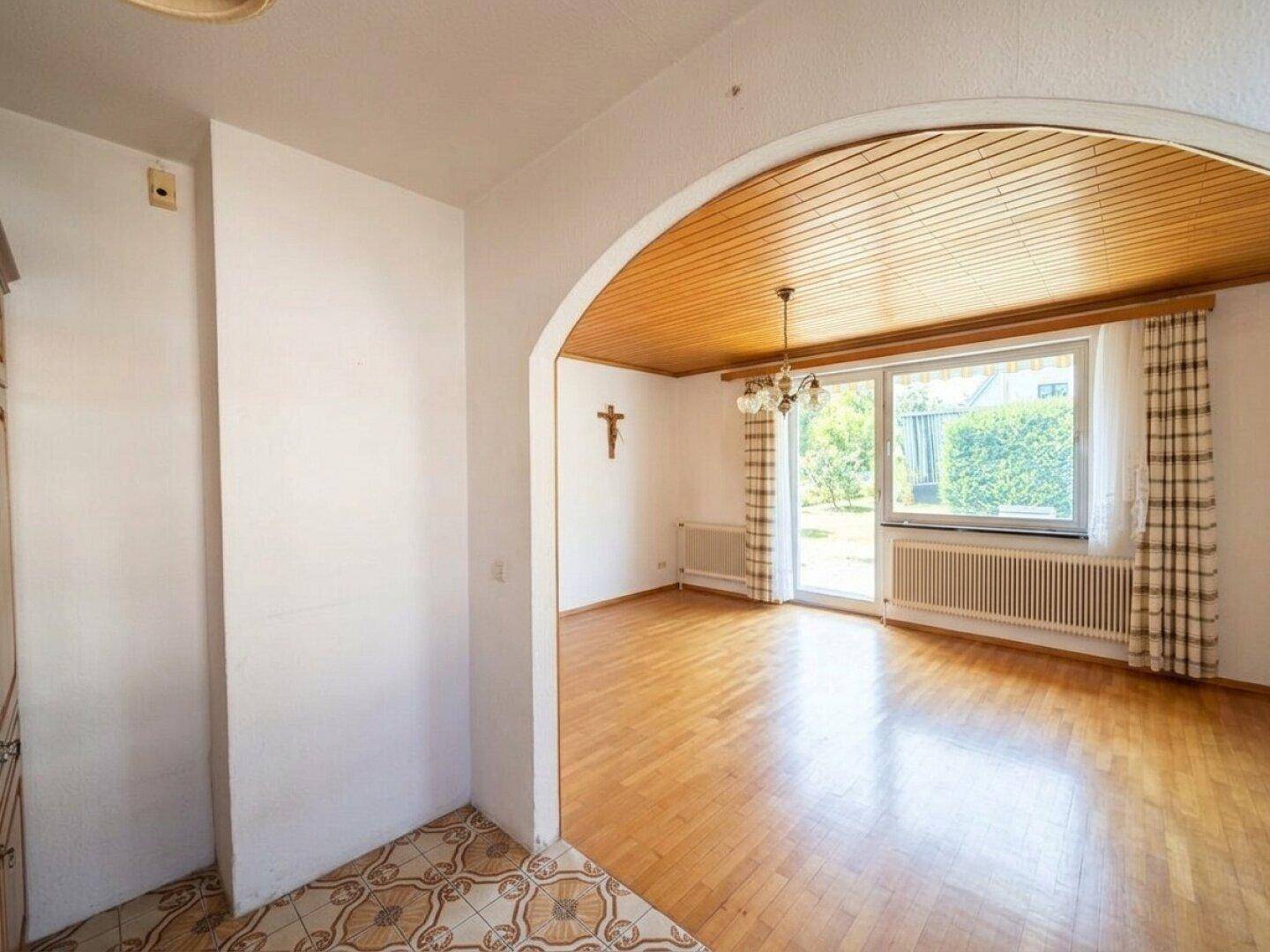 Helles Wohnzimmer mit Parkettboden, Holzdecke und direktem Zugang zum Garten.