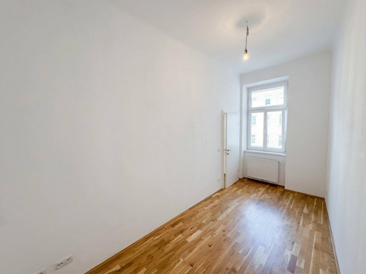 Kleiner, heller Raum mit Parkettboden und einem Fenster, ideal als Kinder- oder Arbeitszimmer.