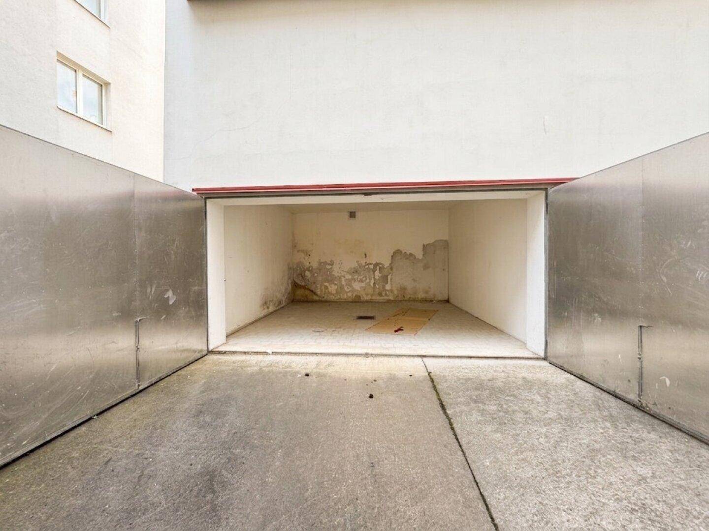Nahaufnahme einer offenen Garagentür, die einen leeren Innenraum freigibt.