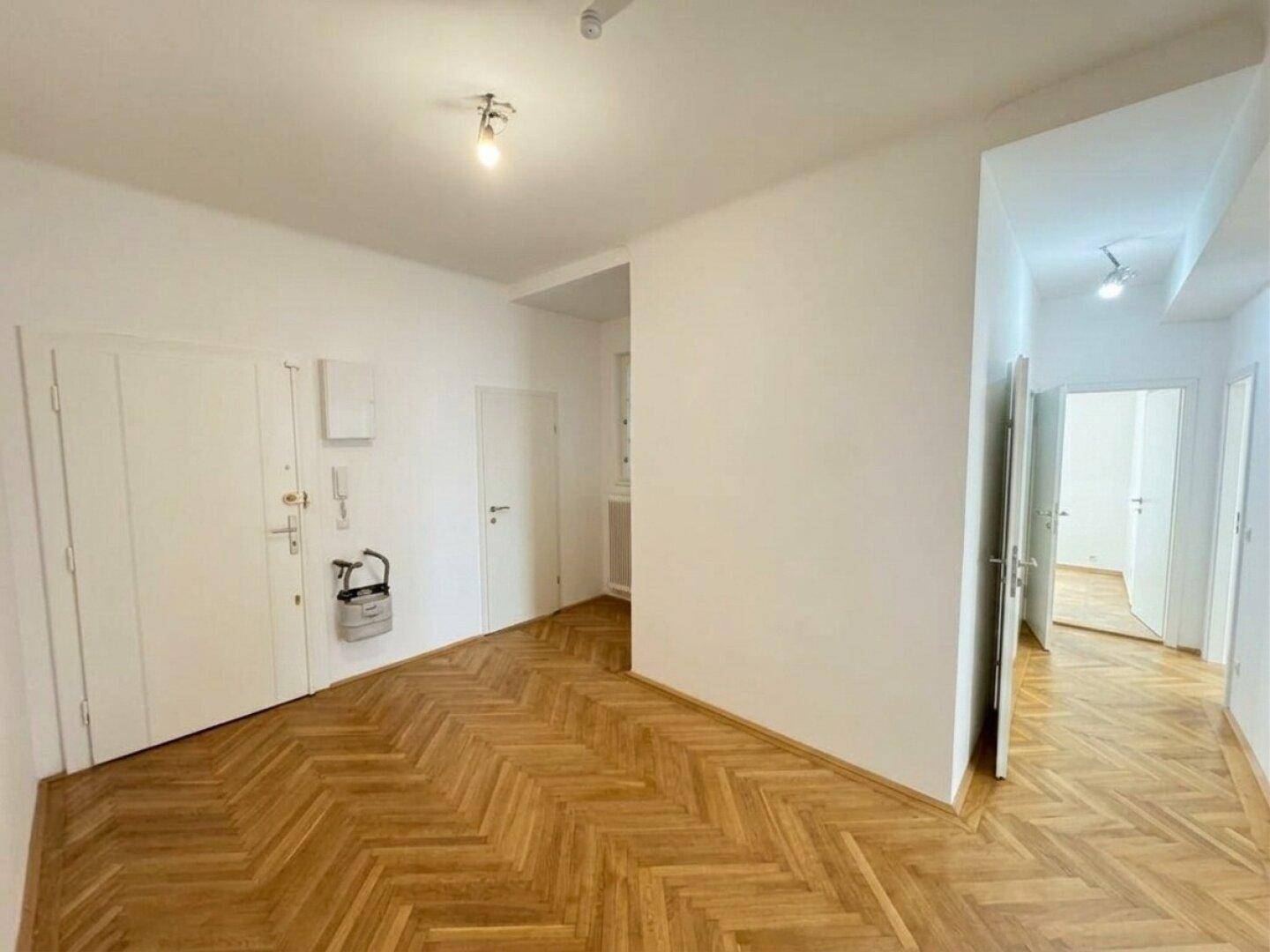 Eingangsbereich mit Fischgrätparkett und praktischen Einbauschränken für zusätzlichen Stauraum.