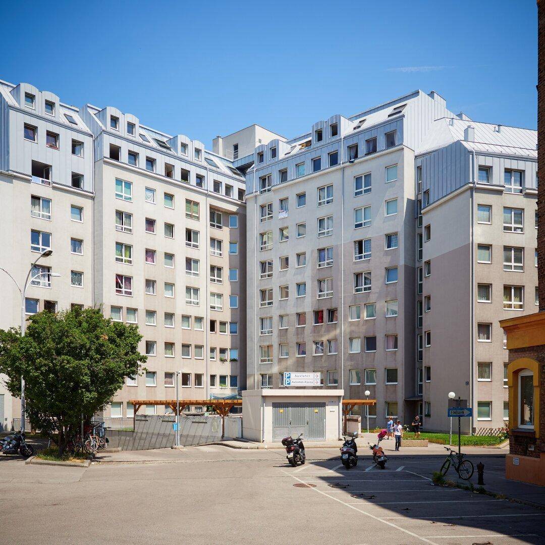 Mehrstöckiges Wohngebäude mit vielen Fenstern und moderner Architektur in urbaner Umgebung.