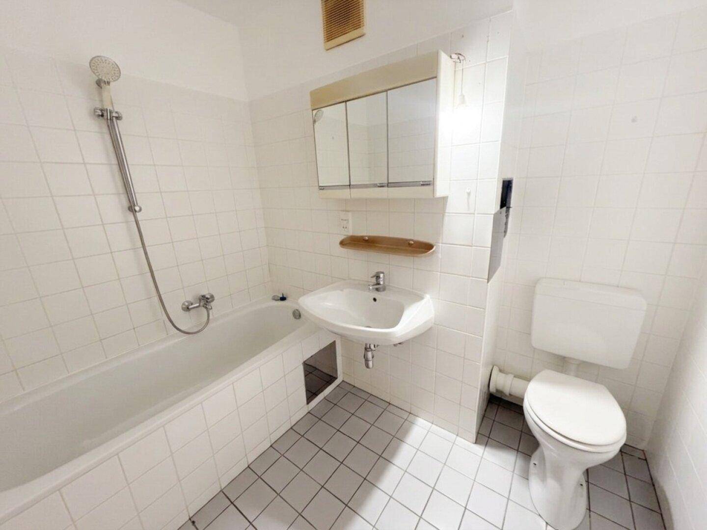 Badezimmer mit Badewanne, Dusche, Waschbecken und Spiegelschrank.