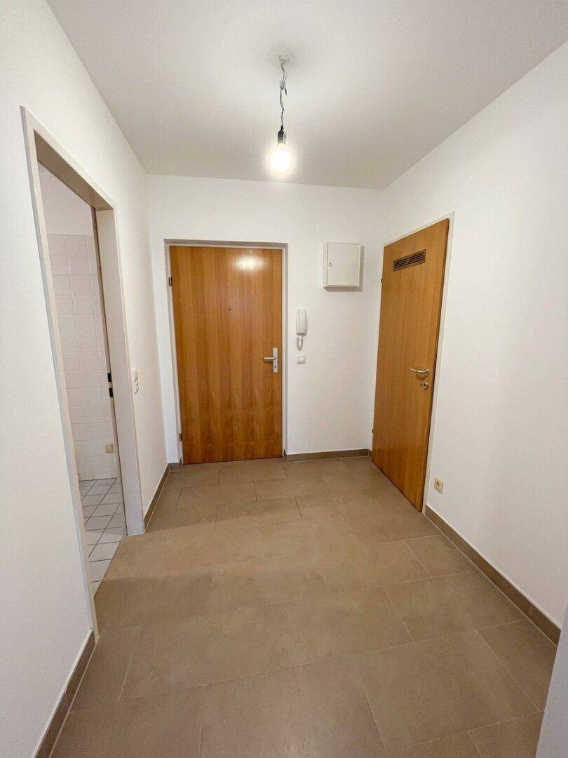 Eingangsbereich mit Fliesenboden und Zugang zu verschiedenen Räumen der Wohnung.