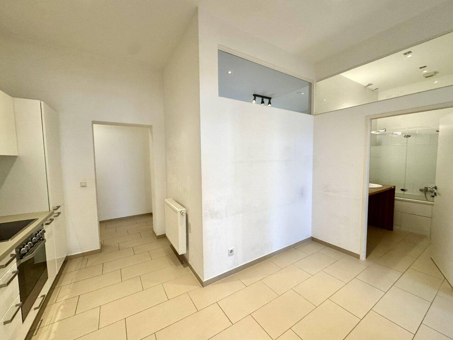 Bereich mit Fliesenboden, der den Übergang zwischen Küche und Badezimmer darstellt.