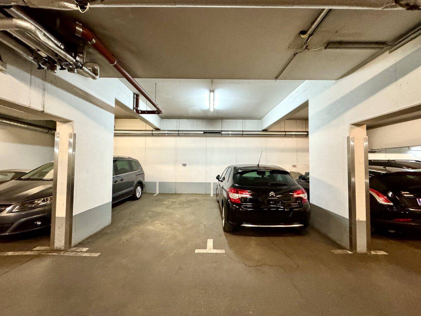 Tiefgarage mit mehreren Stellplätzen und guter Beleuchtung, bietet sichere Parkmöglichkeiten.