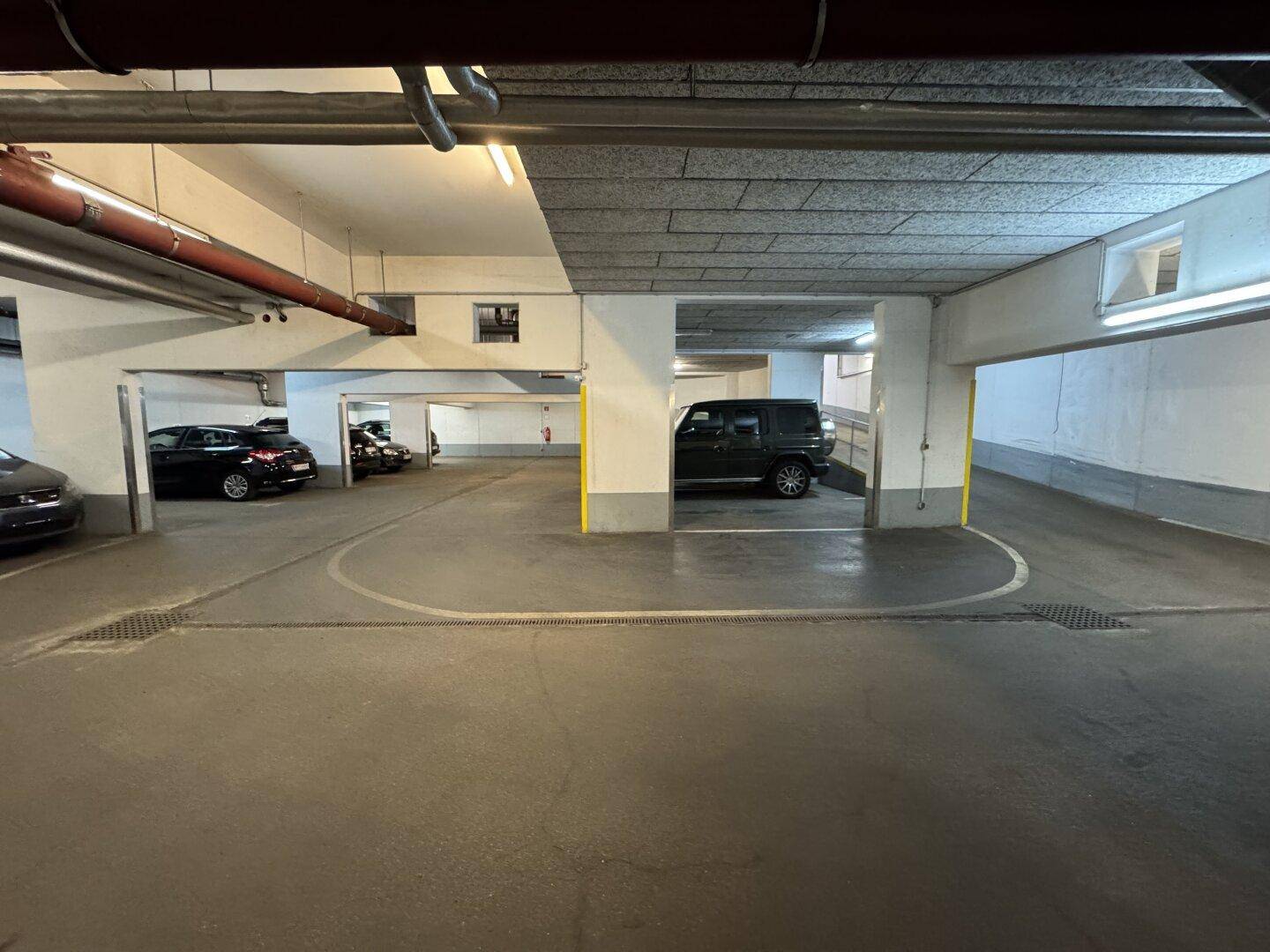 Geräumige Tiefgarage mit breiten Fahrwegen und ausreichend Platz für mehrere Fahrzeuge.