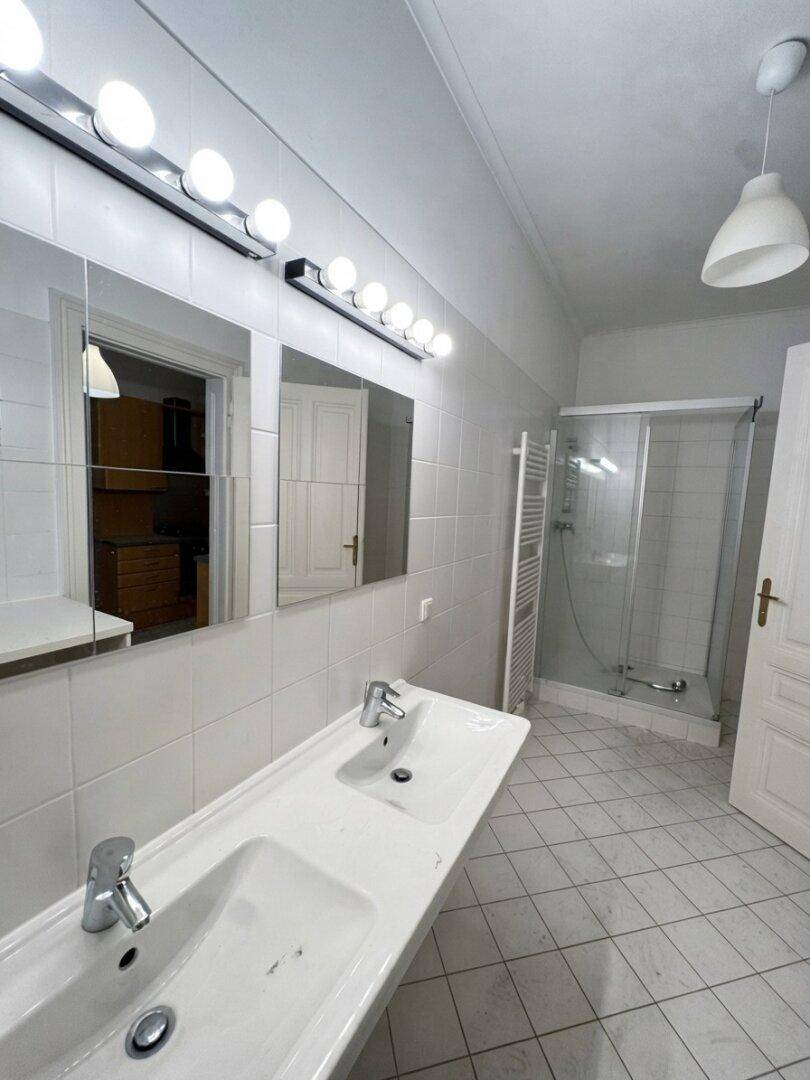 Modernes Badezimmer mit Doppelwaschbecken, Dusche und beheiztem Handtuchhalter.