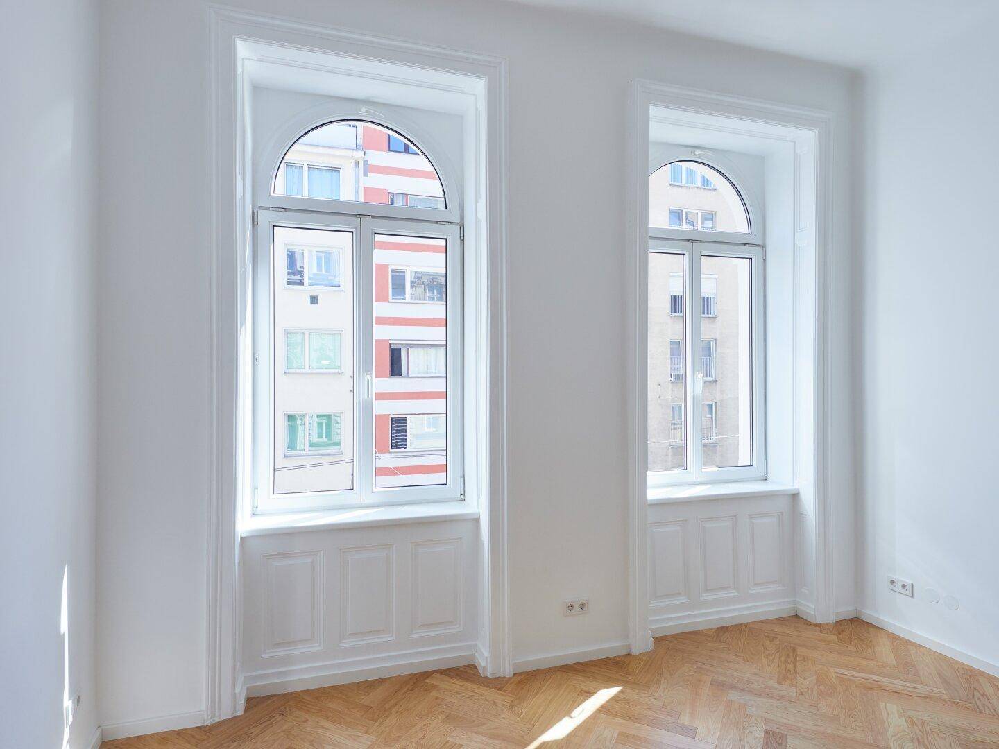 Detailansicht der hohen Bogenfenster mit Blick auf die gegenüberliegenden Gebäude.