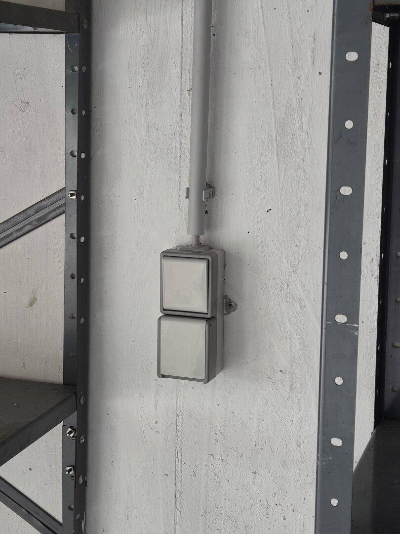 Nahaufnahme eines robusten Lichtschalters an der Wand in der Garage.