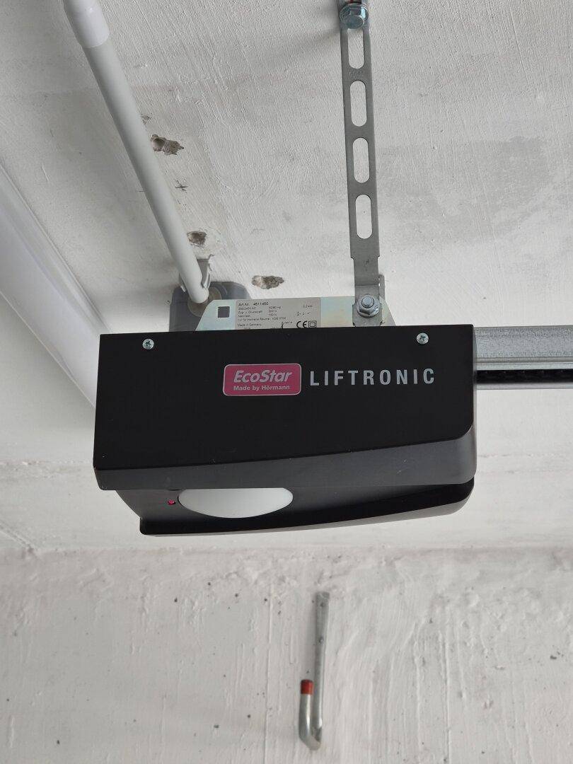 Automatischer Garagentorantrieb der Marke EcoStar LIFTRONIC an der Decke montiert.