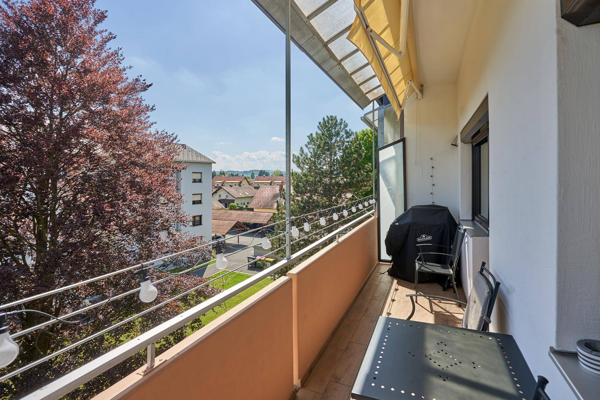 Geräumiger Balkon mit Sitzgelegenheiten, Grill und Blick auf die umliegende Nachbarschaft.