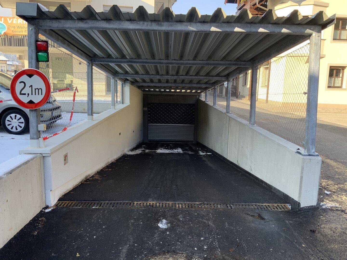 Überdachte Zufahrt zur Tiefgarage mit Höhenbegrenzung.