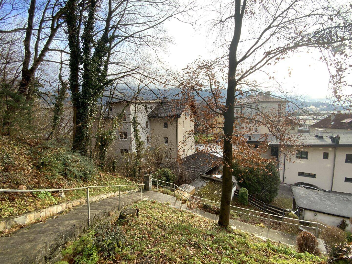 Aussicht von oben auf die Umgebung mit Bäumen, Wegen und Gebäuden.