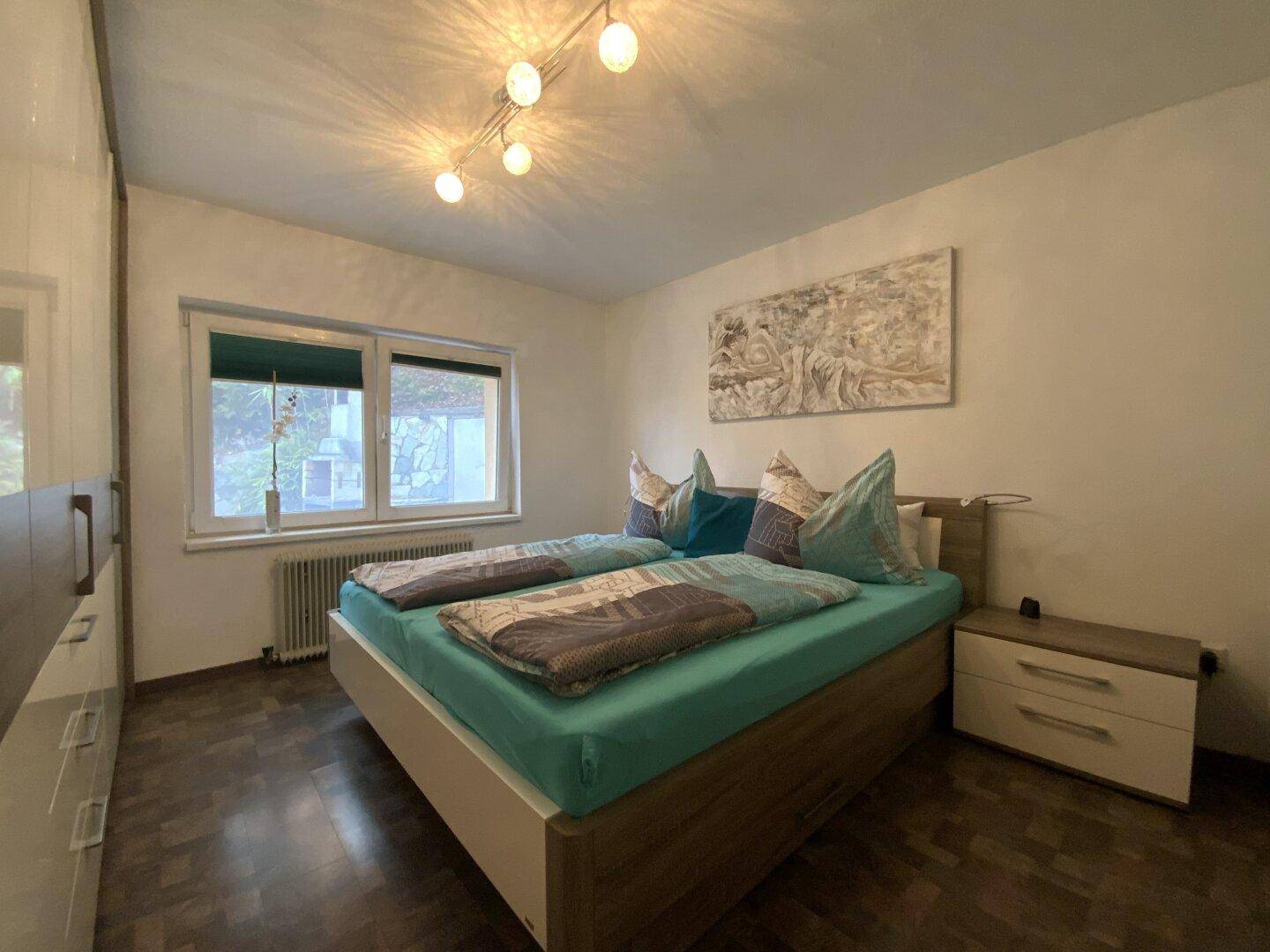 Schlafzimmer mit Doppelbett, Einbauschrank und Laminatboden.